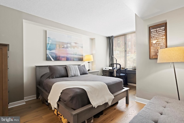 bedroom with a textured ceiling and light wood-type flooring