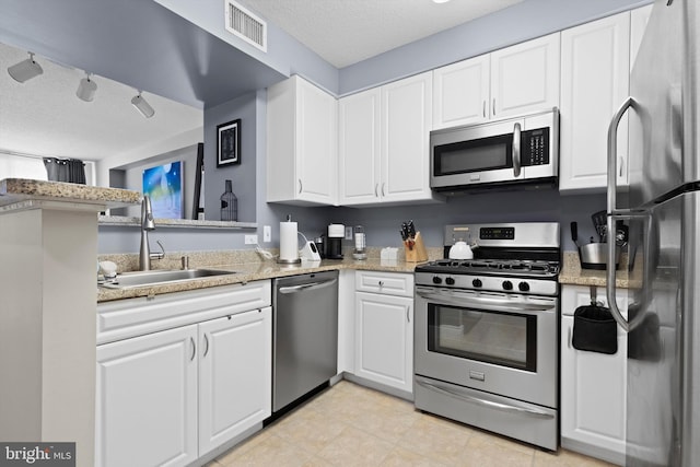 kitchen with white cabinetry, appliances with stainless steel finishes, sink, and a textured ceiling