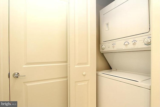 clothes washing area featuring stacked washing maching and dryer