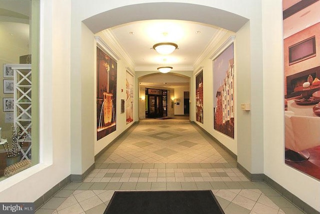 hall featuring light tile patterned floors and crown molding