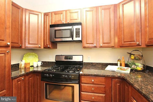 kitchen featuring appliances with stainless steel finishes and dark stone counters