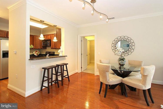 dining room with crown molding and dark wood-type flooring