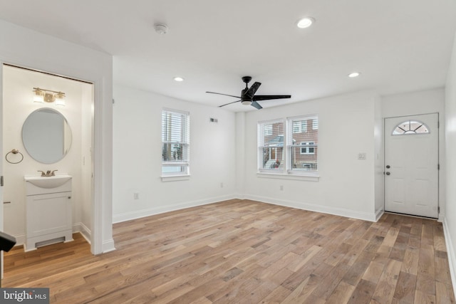 entrance foyer featuring ceiling fan, sink, and light hardwood / wood-style flooring