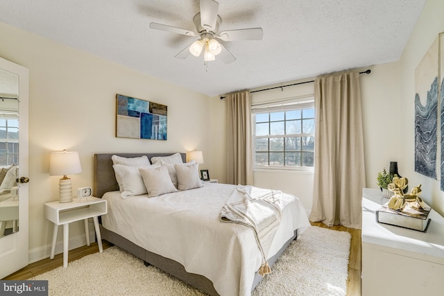 bedroom with multiple windows, light hardwood / wood-style flooring, and a textured ceiling