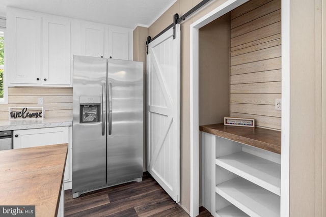 kitchen featuring stainless steel fridge with ice dispenser, dark hardwood / wood-style floors, a barn door, and white cabinets