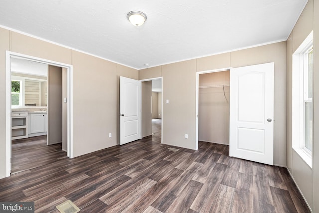 unfurnished bedroom featuring dark hardwood / wood-style flooring and a closet