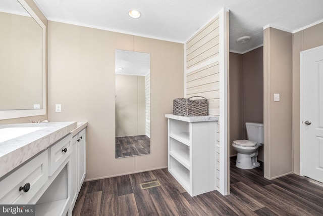 bathroom with wood-type flooring, toilet, and vanity