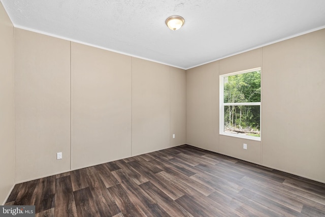 empty room featuring dark wood-type flooring and a textured ceiling