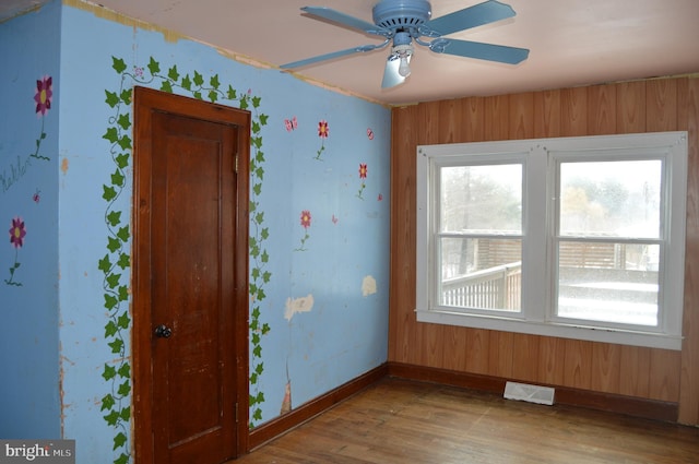 empty room with ceiling fan and light hardwood / wood-style floors