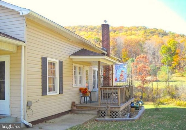 back of property featuring a yard and a deck