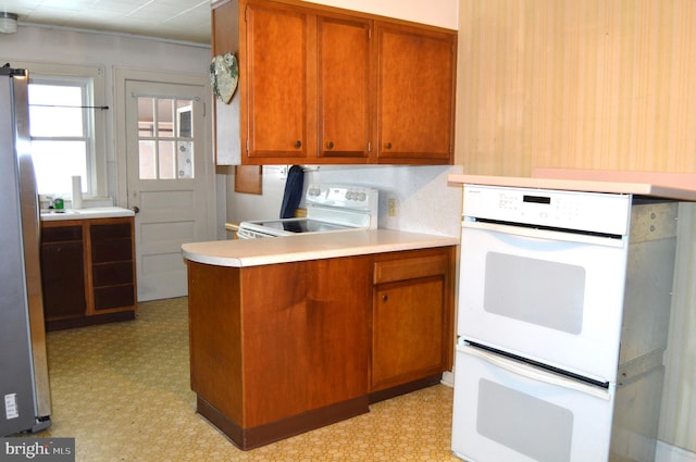 kitchen featuring white appliances and kitchen peninsula