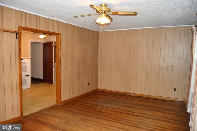 empty room with dark wood-type flooring and ceiling fan