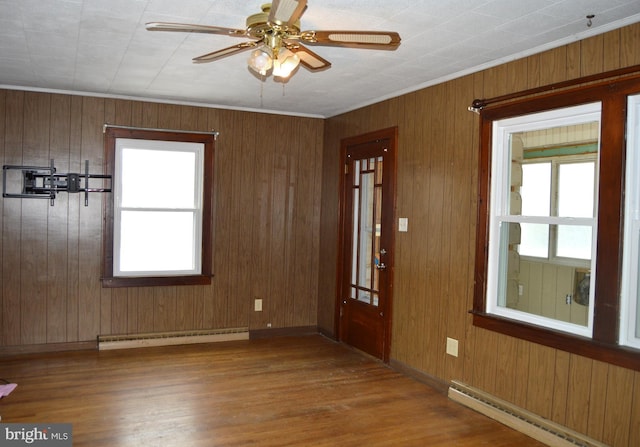 foyer featuring a baseboard radiator, ornamental molding, wood-type flooring, and ceiling fan