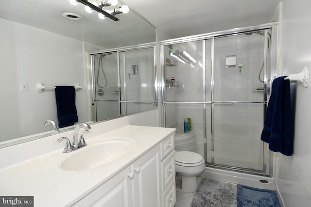 bathroom featuring vanity, walk in shower, tile patterned floors, and toilet