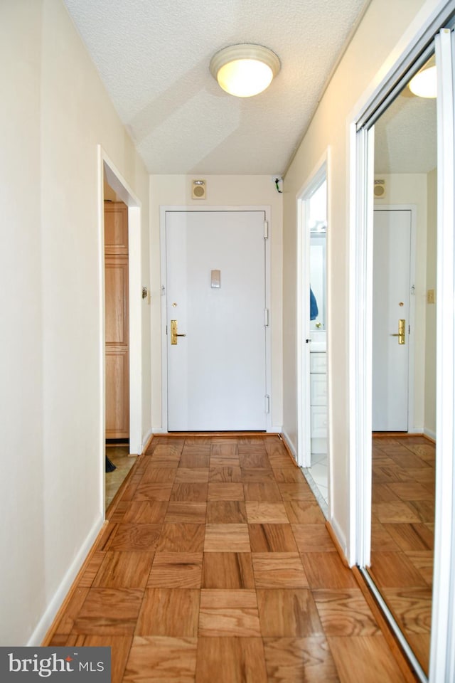 corridor featuring a textured ceiling