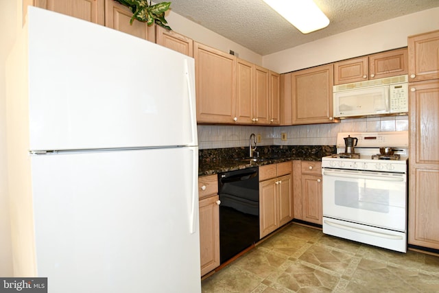 kitchen featuring light brown cabinetry, sink, dark stone countertops, backsplash, and white appliances