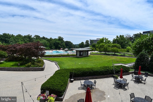 surrounding community featuring a yard, a swimming pool, and a patio area