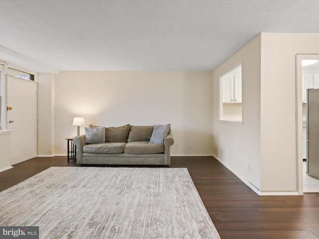 living room featuring a textured ceiling and dark hardwood / wood-style flooring