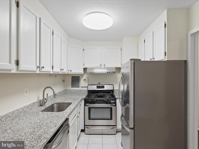 kitchen with light stone counters, stainless steel appliances, sink, and white cabinets