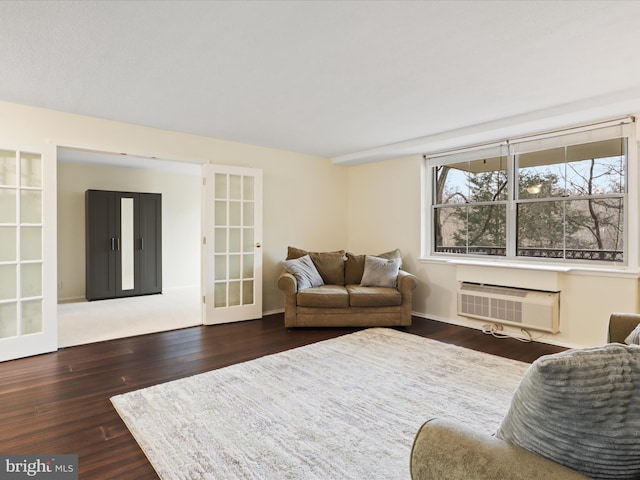 living room with dark wood-type flooring, an AC wall unit, and french doors