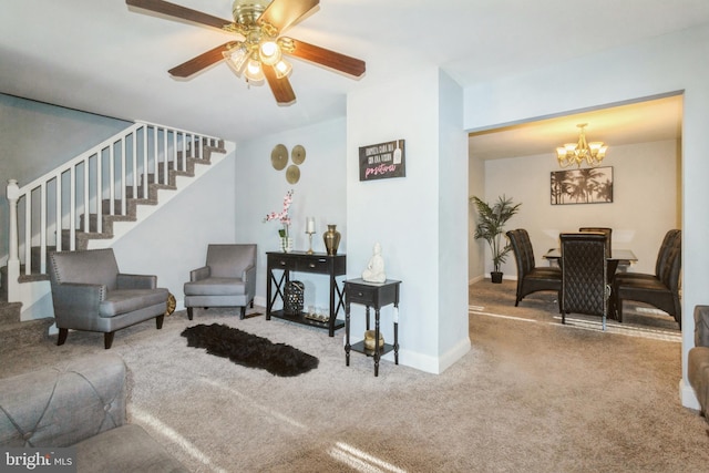 sitting room with baseboards, stairway, carpet flooring, and ceiling fan with notable chandelier