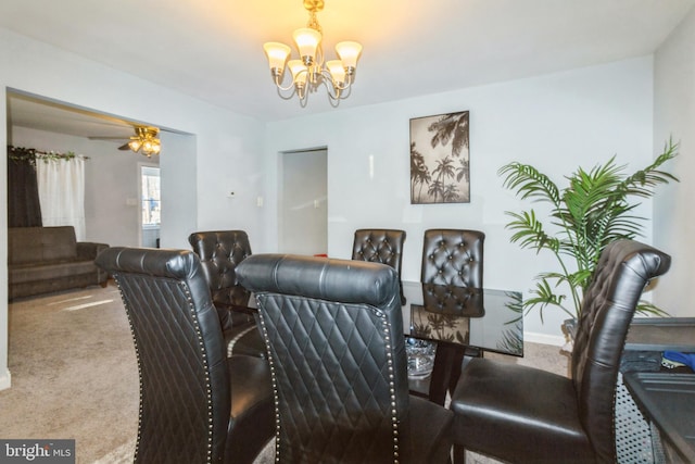 dining space with carpet floors and ceiling fan with notable chandelier