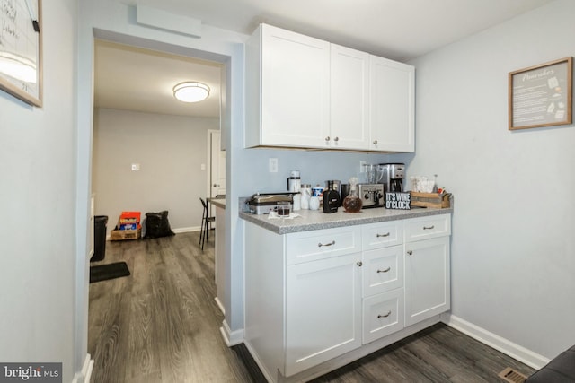 kitchen featuring dark wood-style floors, white cabinetry, and baseboards