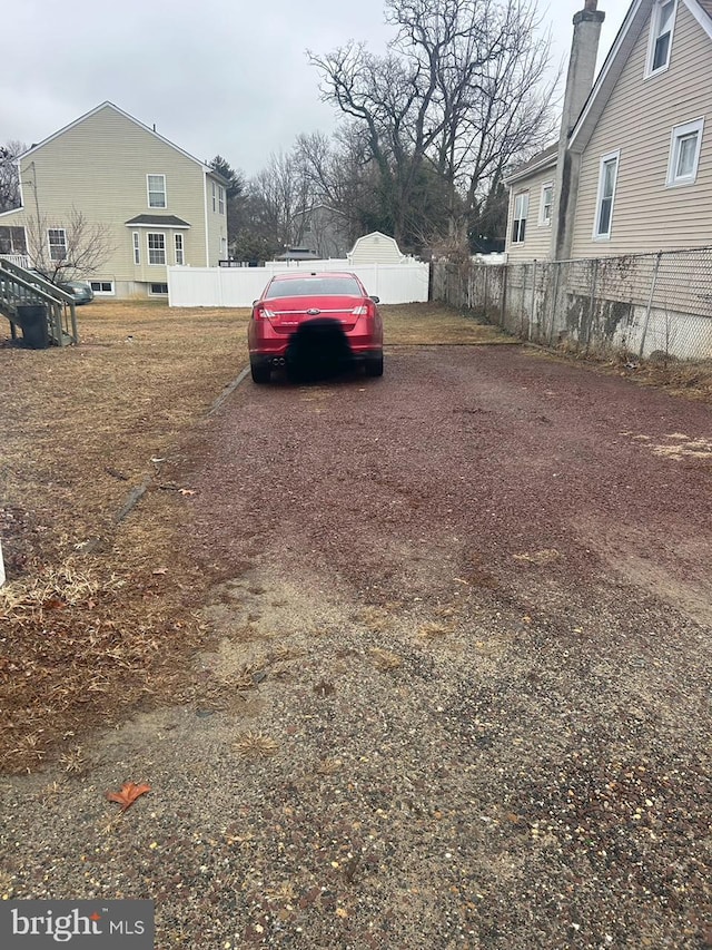 view of yard featuring driveway and fence