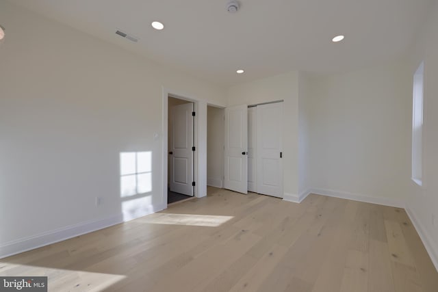 empty room with a barn door and light wood-type flooring