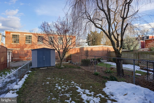 snowy yard featuring a shed