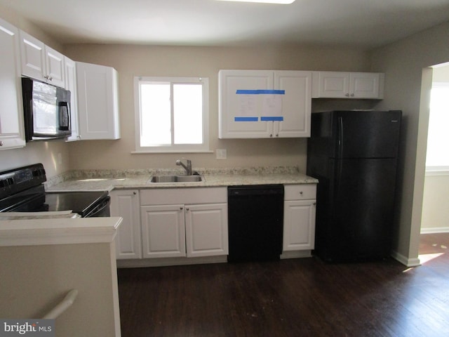 kitchen featuring dark wood-type flooring, white cabinets, sink, and black appliances