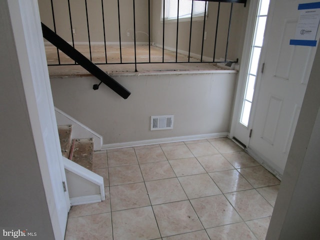 entrance foyer featuring light tile patterned floors and a healthy amount of sunlight