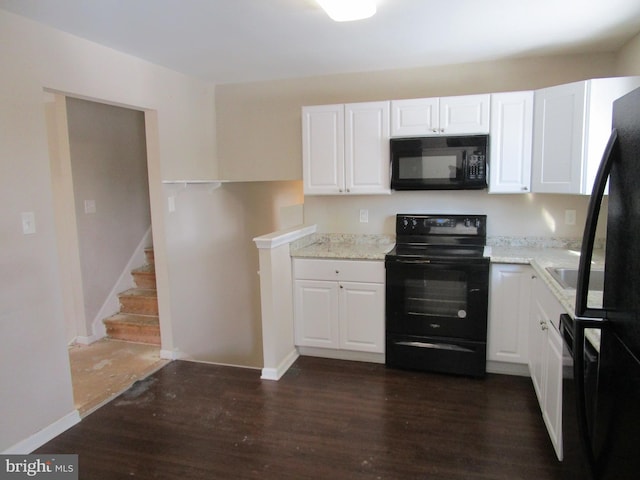 kitchen featuring light stone counters, white cabinets, dark hardwood / wood-style floors, and black appliances