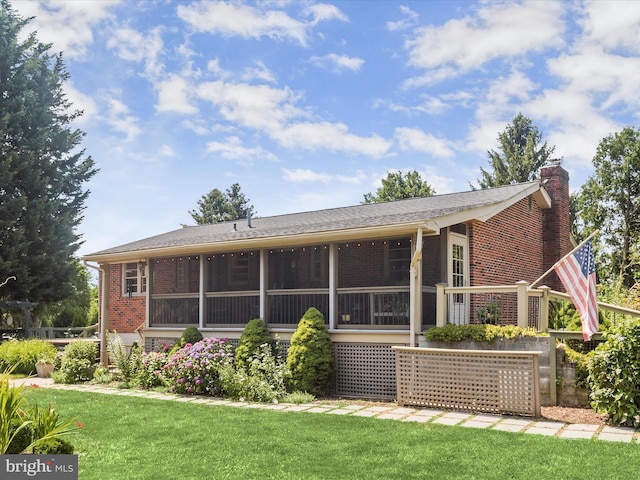 back of property featuring a yard and a sunroom