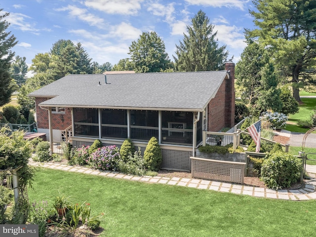 back of house featuring a lawn and a sunroom