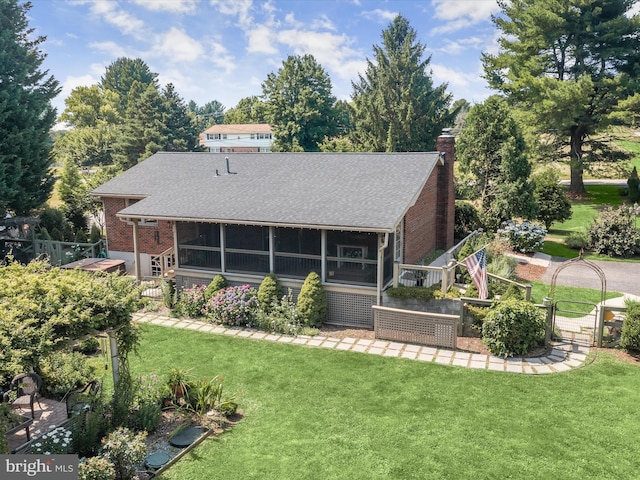 back of property with a yard and a sunroom