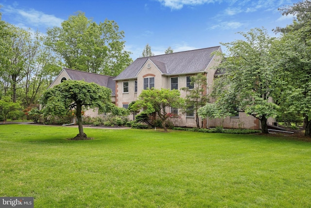view of front of house with a front lawn and a shingled roof