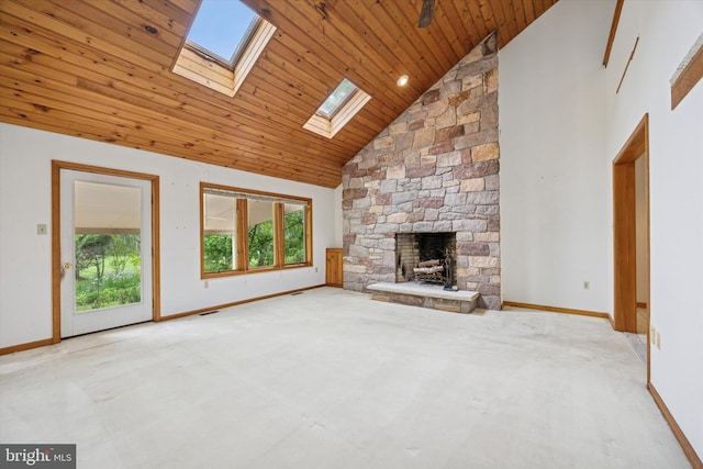 unfurnished living room with a skylight, high vaulted ceiling, wooden ceiling, baseboards, and a fireplace