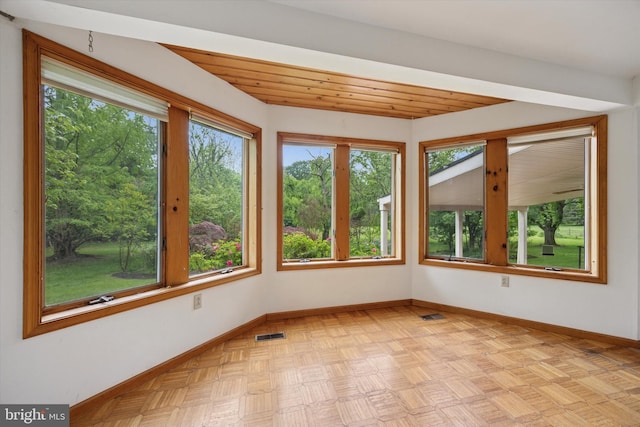 unfurnished sunroom featuring plenty of natural light and baseboards