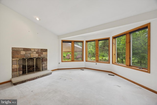 unfurnished living room featuring baseboards, carpet flooring, a fireplace with raised hearth, and lofted ceiling