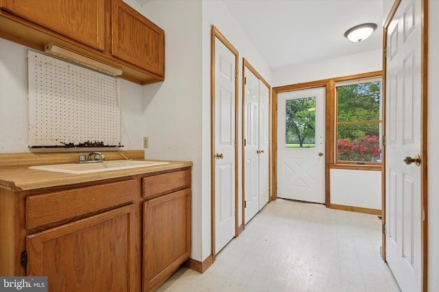 laundry room with a sink and baseboards