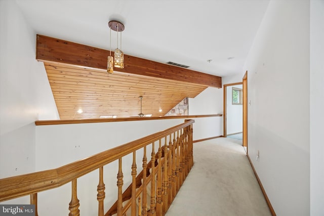 hall featuring light carpet, vaulted ceiling, an upstairs landing, and baseboards