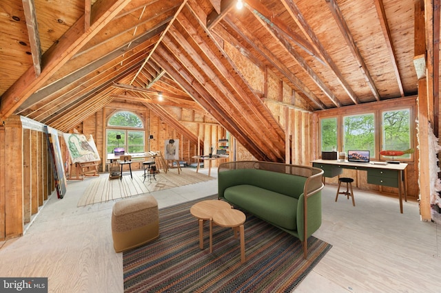 living area featuring lofted ceiling and a desk