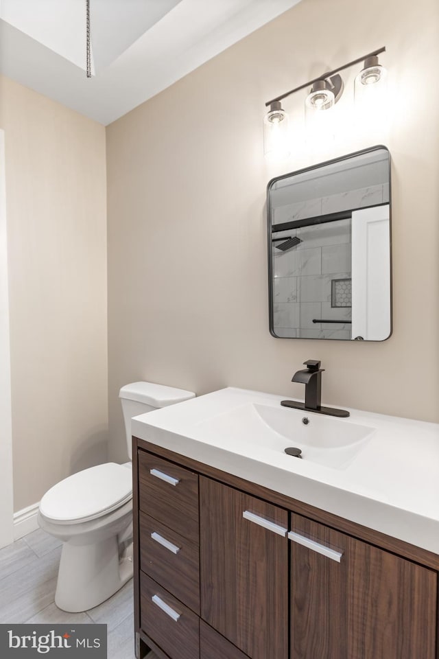 bathroom featuring vanity, toilet, and a shower