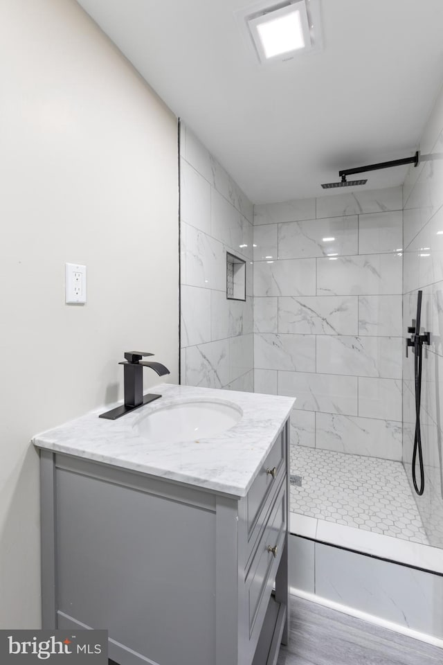 bathroom with vanity and a tile shower