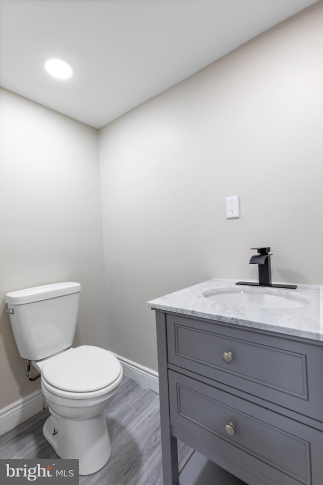 bathroom with vanity, hardwood / wood-style flooring, and toilet