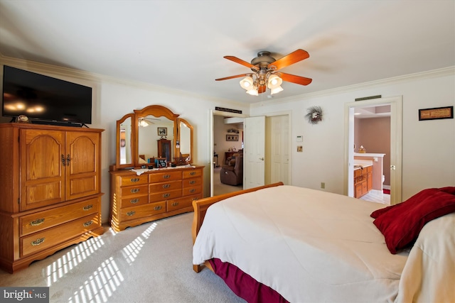 carpeted bedroom featuring ensuite bath, ornamental molding, and ceiling fan