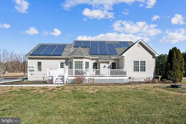 back of property with a wooden deck, a yard, and solar panels