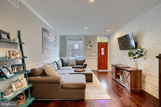 living room featuring crown molding, brick wall, and dark hardwood / wood-style floors