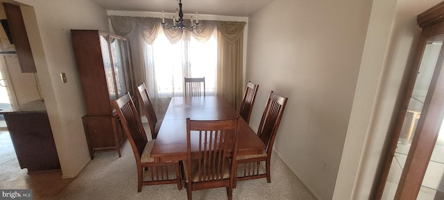 dining space with an inviting chandelier and light colored carpet